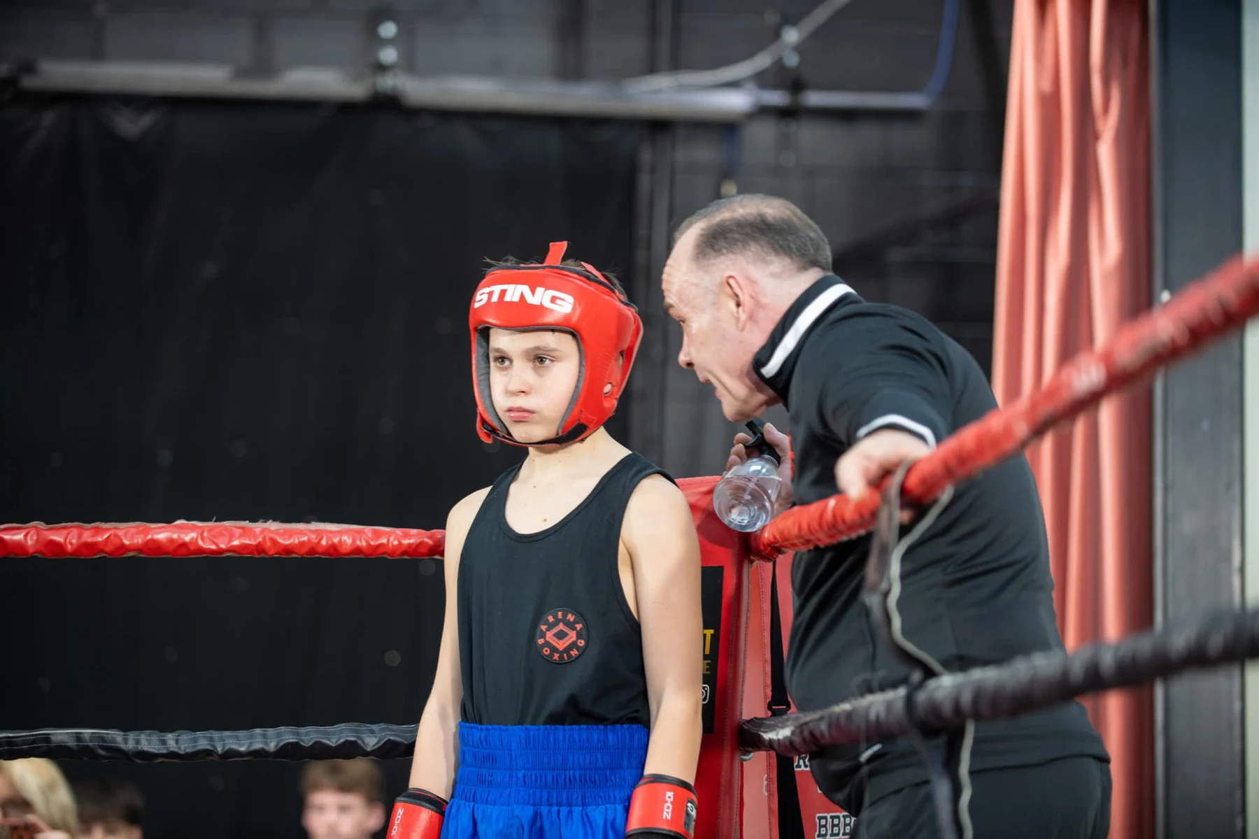 Young Arena boxer receiving ringside guidance before a bout